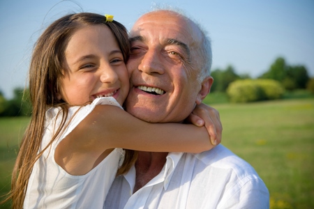 A young girl held by her foster father