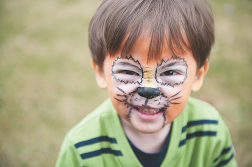 Child with face painted like a tiger