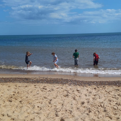 Children paddling in the sea, at the beach.
