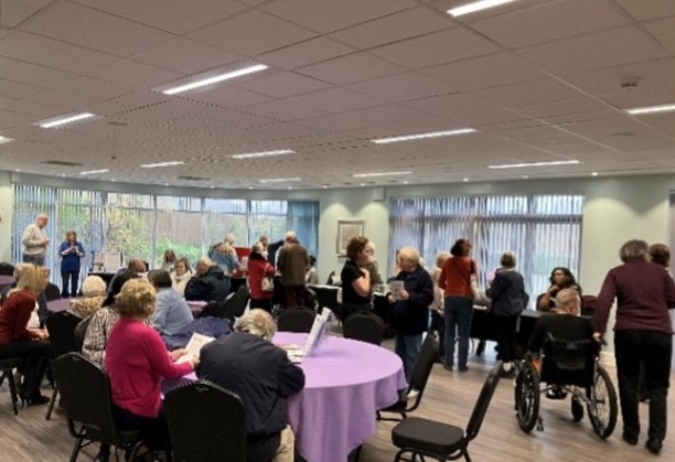 People at one of our tenant open days. They are talking in different groups, some seated and some standing.