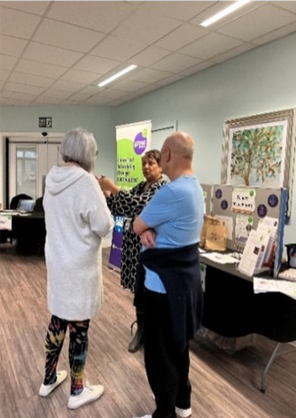 Two people talking to one of our team about housing at one of our housing hubs