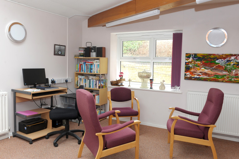 Communal lounge with computer workstation, bookshelves and seating at Baker Street independent living scheme.