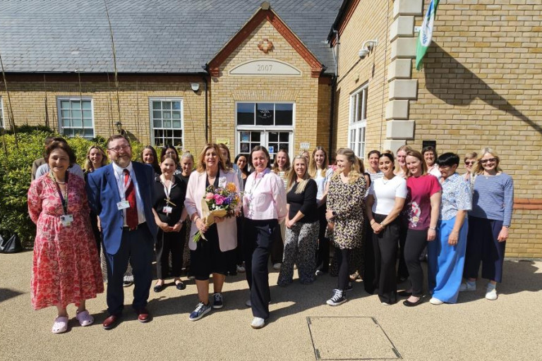 Group photo outside a school building.  Front row: Cllr Liz Childs, Cllr Gareth Mackey, Mrs Stone and Amana Gordon, with school staff behind.