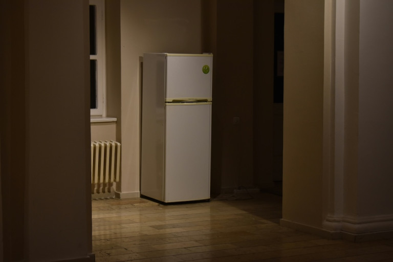 A fridge-freezer, in the corner of a room