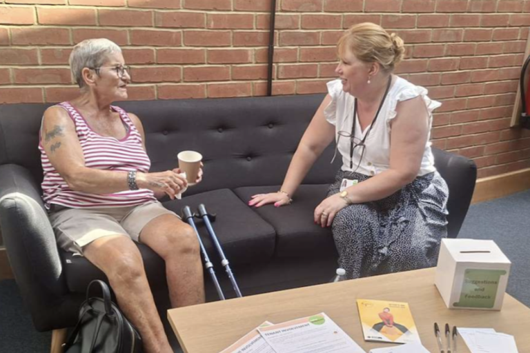 An image of a housing tenant talking to a member of the housing team. 
