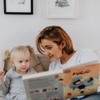 Foster carer reading a book to a child