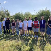 Students stood in front of a thriving Tiny Forest at the student programme celebration event hosted by Cranfield University.