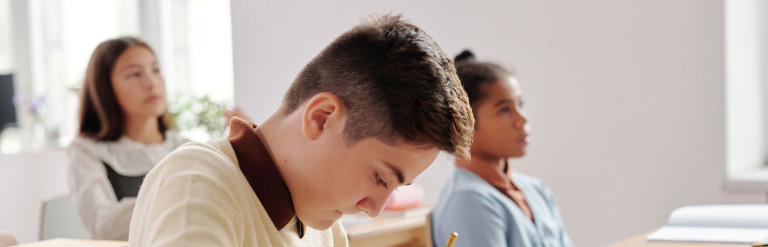 Young people sitting at school desks
